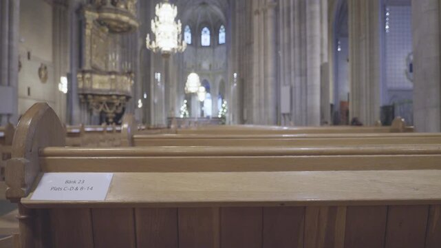 A tranquil view of the interior of a church featuring wooden benches, soft lighting, and a sense of calm. The architecture highlights spiritual tranquility and offers a place for reflection.