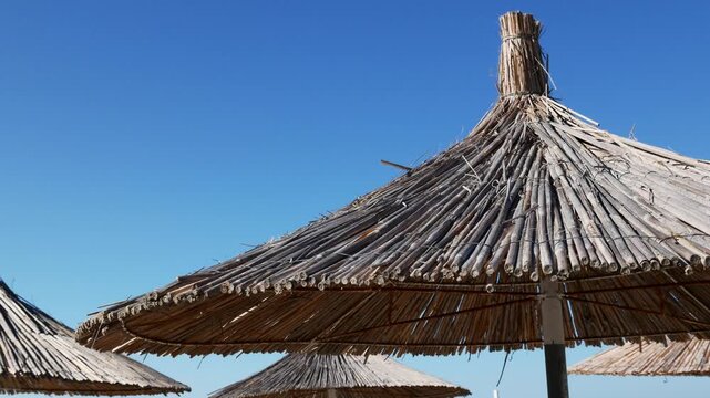 Bamboo beach parasol and blue sky, tropical resort vacation, sunny coastal tourism and summer lifestyle.