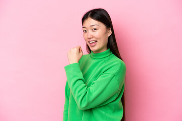 Fototapeta premium Young Chinese woman isolated on pink background celebrating a victory