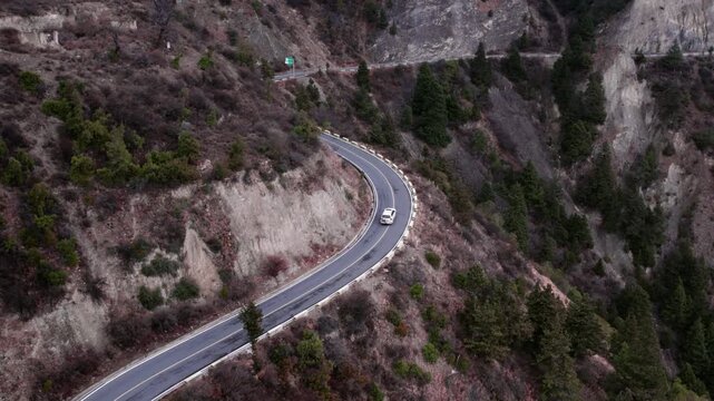 White Van Driving on Winding Mountain Road
