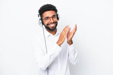 Fototapeta premium Telemarketer Brazilian man working with a headset isolated on white background applauding after presentation in a conference