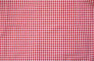 Fototapeta premium Red and white check table cloth background. Top view. Copy space. Summer outdoor food or picnic theme.