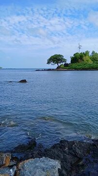 Scenic view of Corbyn's Cove Beach in Port Blair, Andaman and Nicobar Islands, India with calm blue sea and rocky shore.