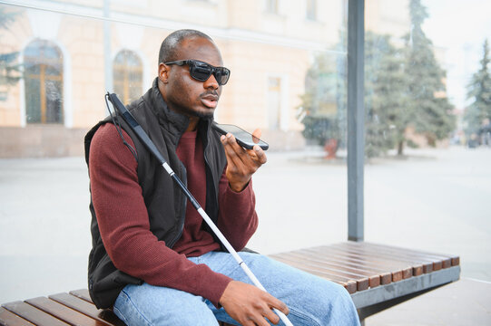African american blind man using smartphone voice assistant