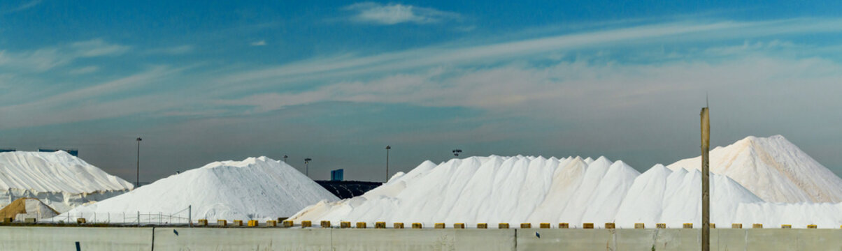 The large white mounds are likely stockpiles of rock salt, commonly stored at shipping terminals to be distributed for winter road maintenance.