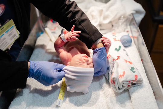 Newborn being measured by nurse after birth in hospital 