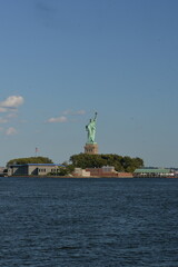 Obraz premium Statue Of Liberty Stands Tall Over Bustling Harbor With City In Background new york