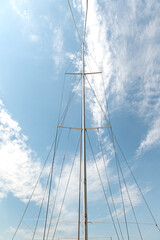 Obraz premium A yacht mast against a blue sky. Vertical photo.