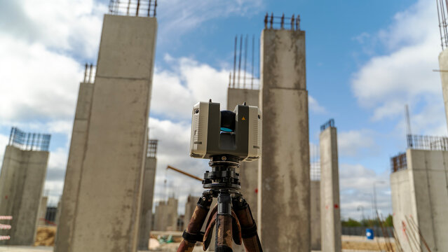 Concrete pillars rise behind a laser level