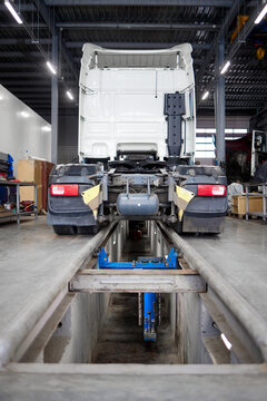 This image depicts a sleek, modern truck resting strategically on a maintenance pit. Perfect for illustrating vehicle inspections, repairs, and automotive services in a contemporary garage setting.