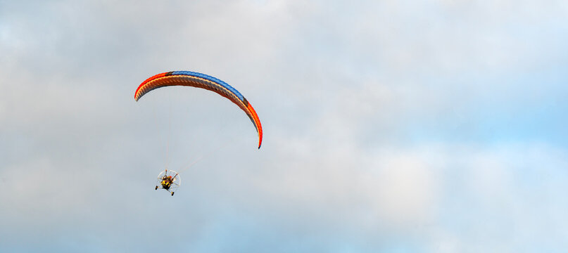 Paraglider soars above soft clouds
