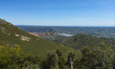 Fototapeta premium Lake with trees and a hill formation on the horizon.