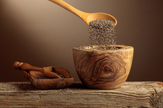Chia seeds is poured into a wooden bowl.