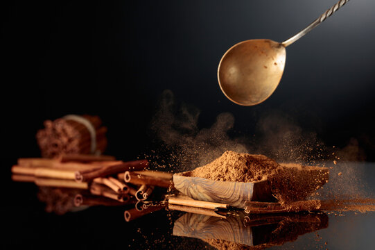 Cinnamon powder is poured into a wooden dish.