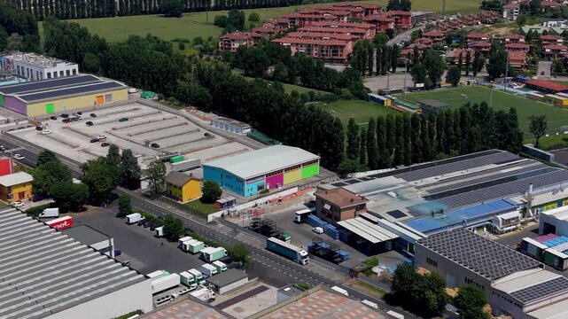 Industrial Landscape from Above: An aerial view captures a sprawling industrial park with a network of warehouses, roads, and vehicles, showcasing the hub of manufacturing and logistics.