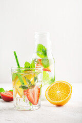Fototapeta premium Summer detox beverage concept. Citrus fruit drinks with ice. Healthy diet cocktail with fresh berries and mint