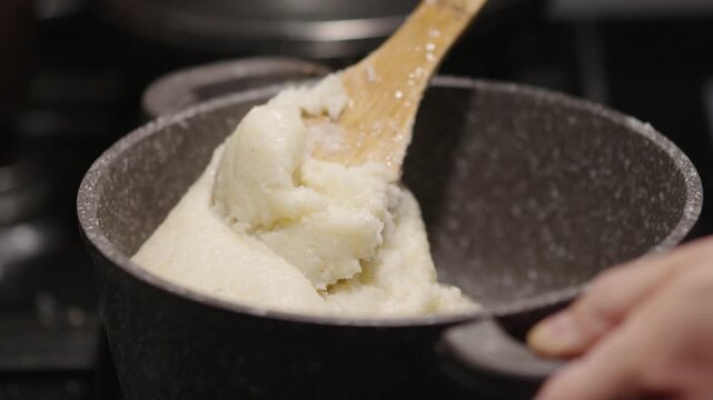 Cooking ghomi, a popular dish from the Samegrelo region made with coarse white corn flour