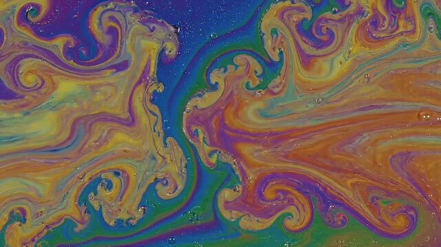 Macro view of iridescent soap bubble with vibrant rainbow colors and swirling patterns of purple blue green yellow and orange with small air bubbles against a dark background. Keywords: soap