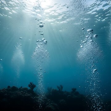 Sunlight pierces underwater, illuminating rising air bubbles and coral