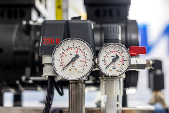 Air Compressor Pressure Gauges Close Up. Close-up of pressure gauges and control components on an industrial air compressor used for dental or medical equipment.