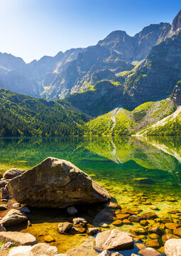 landscape with lake in mountains. scenic nature of poland with rocky summit reflection on the lake surface in summer. view of wonderful place in high tatra mountains for travel in eastern europe