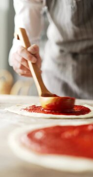 Close up of woman hands preparing pizza in kitchen