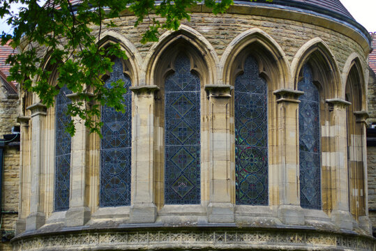 Architectural details of a traditional stone cathedral apse with a row of gothic arched windows.