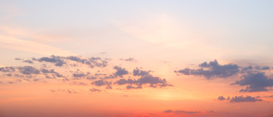 Fototapeta premium Soft sunset light fills sky with warm tones. Cottony clouds float against colorful horizon. Pink and purple shades blend into setting sun. scene brings a serene, tranquil feeling