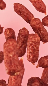 Mini sausages flying on a pink background. Filmed on a high-speed camera at 1000 fps. High quality FullHD footage