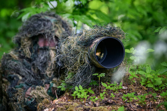 Wildlife photographer in the summer ghillie camouflage suit