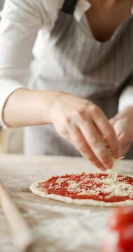 Close up of woman hands preparing pizza in kitchen