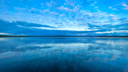 Fototapeta premium Mirror-Like Water Reflections Under Blue Cloudy Sky – Minimalist Coastal Seascape Panorama