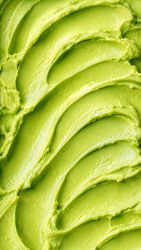 Creamy avocado mousse texture surface close up shot displaying smooth ripples of smashed green fruit.