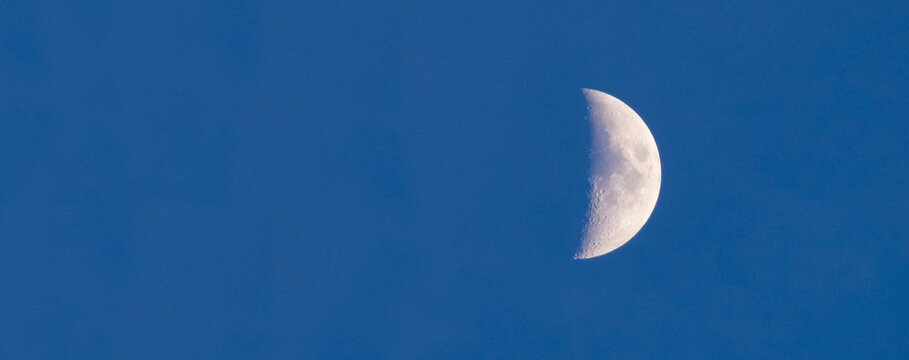 Crescent moon against a clear blue sky, evoking calm nighttime serenity