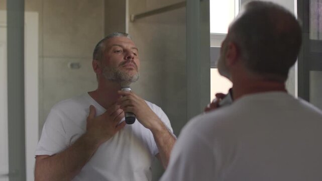 Man shaving hair on neck in bathroom, looking at mirror, 4k