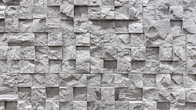 white and grey geometric stone wall texture with square relief pattern and decorative surface.