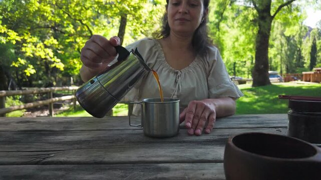 Mother Pours Coffee for Daughter Outdoors.