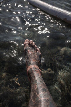 Fish tattoo on foot over ocean