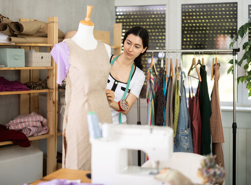 Armenian fashion designer works with fabric on a mannequin, she checks the size of the sample and makes edits. Process of creating clothes