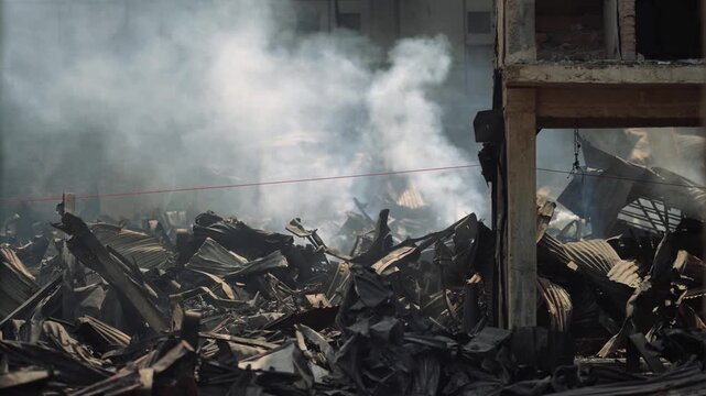 Dhaka, Bangladesh - 13 May 2026: View of thick white smoke rising from twisted metal debris and destroyed structures after a major fire in the city.