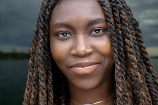 Close-up portrait of young African woman at lake, summer night outdoor