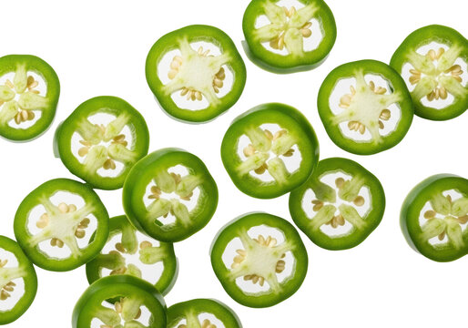 Freshly sliced vibrant green serrano peppers, round cross-sections with pale interior and glistening seeds, suspended dynamically on a transparent background, copy space. Concept of fresh spicy