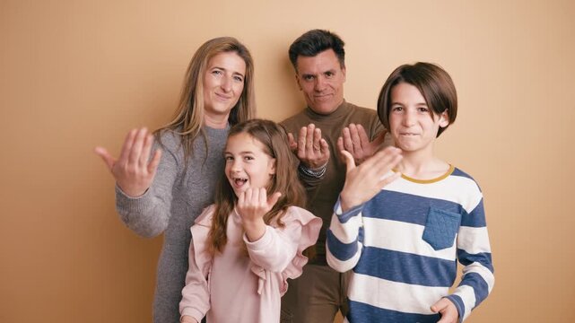 Cheerful family with son and daughter gesturing to come here. Parents and children together making beckoning hand signs and smiling