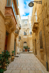 Obraz premium Cozy street and traditional colorful wooden balconies in Birgu, Malta
