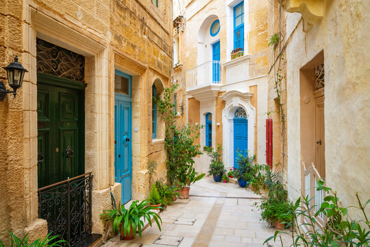 Cozy street and traditional colorful wooden balconies in Birgu, Malta
