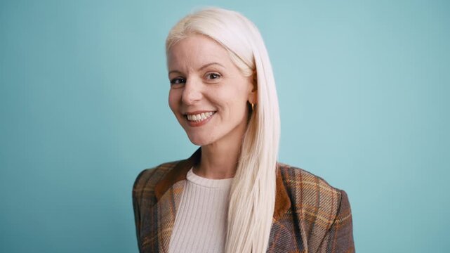 Portrait of a happy mature woman with platinum blonde hair smiling at the camera. Beautiful businesswoman showing confidence and success