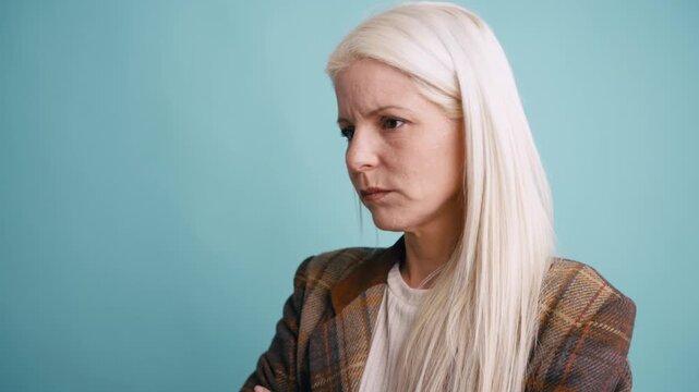 Unhappy and disappointed middle aged woman with long blonde hair expressing negative emotions. Displeased person feeling angry and frustrated