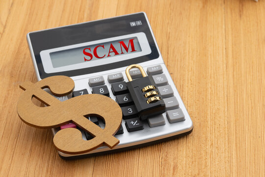 Scam alert on house with twenty dollar bill cash with calculator on wood desk