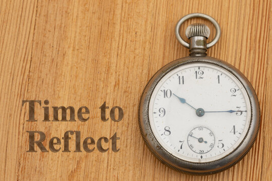 Time to Reflect text with a pocket watch on wood desk for nostalgia and legacy