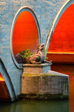 Traditional mythical dragon statue on the stone pier of illuminated Anshun Bridge, Chengdu, Sichuan, China